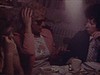 Femmes autour d’une table discutent et mangent, un homme tient un bébé dans ses bras. au salon, les gens essaient de faire marcher le bébé - premiers pas - 1975