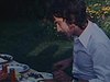 Deux hommes et une femme font un repas à l’extérieur, les gens se servent à manger et sourient à la caméra - nourriture