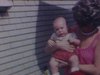 Femmes avec un bébé dans les bras dans la cour de la maison, puis un jeune couple au jardin avec l’enfant