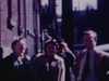Un groupe d’adultes marchent dans la rue puis vers un appartement, des enfants sortent dehors et posent avec leurs parents - oct. 63