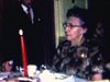 Anniversaire d’une femme âgée (86 ans) famille autour de la table de la salle à manger, une femme sert les invités, les enfants saluent la caméra et font des singeries