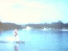 Un homme fait du ski nautique, un autre part du quai, puis rentre et range la corde avec une femme qui sort du bateau (1962)