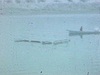 Images embrouillées et blanchâtres: religieuses dans une chaloupe à moteur sur un lac. Deux religieuses, deux homme et une femme tenant dans ses bras son enfant; ils discutent, se serrent la main et se font la bise devant une automobile. Deux soeurs vues 