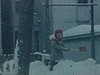 Enfants en habits de neige jouent avec des pelles dans une ruelle