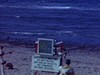 Plage à l’Île-du-Prince-Edouard, panoramique sur la plage, une femme et sa fille vont se baigner, un garçon joue sur le sable, père et fille sur une serviette au soleil
