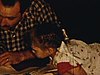 Un petit garçon fait ses devoirs avec son père et son petit frère et sa petite soeur