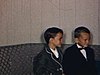 Trois enfants assis sur le divan en beaux habits, une femme vient les chercher puis ils partent en automobile, l’auto sort de la cour de la maison