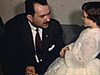 Un homme et une femme parlent à une fille en habit de première communion au salon