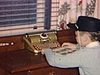 Petit garçon avec un chapeau de cowboy lit une bande dessinée, il se retourne vers la caméra et sourit