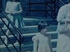 Deux femmes âgées accompagnées d’une petite fille descendent les escaliers, elles rejoignent la famille et posent pour la caméra