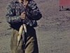 Un garçon avec un chapeau de cowboy marche vers la caméra et montre ses poissons, station-service, une femme sort d’une auto et fouille dans sa sacoche (1965)