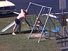 Floride. une fillette dans une balançoire discute avec un homme en maillot de bain, terrain de shuffle board, stationnement, piscine. des gens se prélassent au soleil