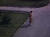 Un homme marche vers une piscine publique, met un casque de bain et va se baigner, (filmé d’une chambre d’hôtel)