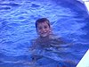 Deux petits garçons et une petite fille se baignent dans la piscine, petit garçon sourit à la caméra - 1988