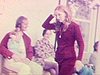 Réunion de famille à la maison de campagne: les gens sont assis dehors sur la galerie, discutent, un homme et une fille sont assis sur le capot de la voiture - 1972  