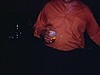 Un homme dans le sous-sol d’un bungalow marche avec un verre de bière dans les mains et une cigarette dans la bouche, il va s’accoter au bar