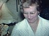 Des adultes âgés dans le salon, un homme s’amuse à poser pour la caméra avec des femmes. ils rigolent beaucoup et discutent. - 1972-1975