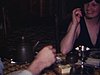 Une famille à la cuisine, les gens discutent et mangent directement au plat au centre de la table, télévision allumée sur le comptoir de la cuisine (1977)