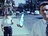 Des hommes marchent vers la caméra dans une rue de Montréal - 1958. Des femmes et des enfants sur la galerie d’un appartement