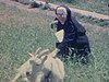 Une religieuse tire une chèvre couchée dans l’herbe, une poule, des boeufs décorés, des chevaux qui tirent un chariot - Upper Canada Village