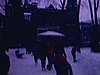 Des gens patinent sur un anneau de glace, un couple se tient par la main, des amis se tiennent par la taille, un enfant tombe
