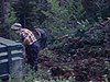 Plan d'un camion stationné, des homme chargent un camion, un petit garçon fait des singeries devant la caméra, un homme creuse la terre et un petit garçon enlève les mauvaises herbes avec des longues pinces, deux femmes sont assises et regardent les gens 