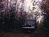 Un camion dans un sentier en forêt, un garçon marche avec un lièvre mort dans les mains, il revient au campement avec un homme, ils trainent leurs prises, un homme dort dans les branches d’arbre, des hommes pêches