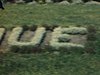 Des enfants marchent devant un parterre en fleurs où est inscrit «Bienvenue» - 1946