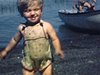 Des enfants en maillots de bain débarquent d’une chaloupe à moteur et marchent sur la plage vers la caméra - années 40