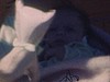 Gros plan sur bébé naissant dans les bras de sa mère, dans une couverture, (image sombre)