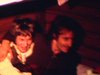 Jeunes couples dans un chalet en bois rond, ils sont couchés sur les lits, boivent de la bière et s’amusent - 1979
