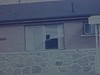 Petit garçon revient de l’école en autobus et il tourne en rond devant la maison, sa mère l’observe par la fenêtre