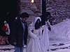 Sortie de l’église des mariés en hiver, habits années 70, ils montent dans une automobile