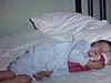 Une petite fille en jaquette fait semblant de dormir en serrant sa poupée 1963