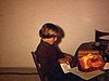 Souper d’anniversaire d’un adolescent, déballe ses cadeaux, sa soeur le regarde, il va la remercier lui donne un baiser sur la joue, carte que les grands-parents ont envoyée, souffle les bougies, maman à côté, papa vient l’aider à couper le gâteau